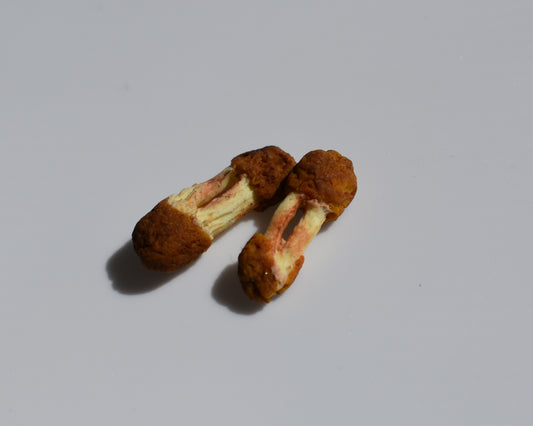 Two small fried, eaten chicken wings, both are flats. They are on a white background.