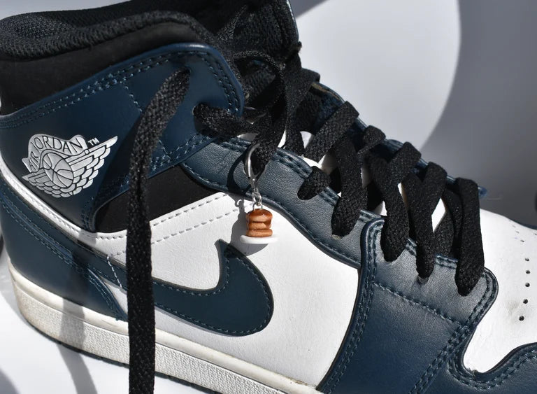Close-up of a blue and white sneaker with black laces on a light gray background