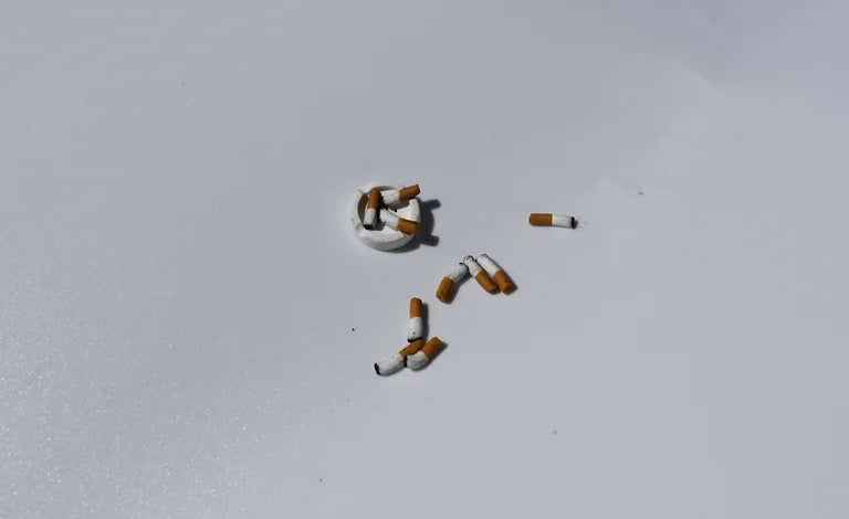Cigarette butts arranged in the shape of a number '5' on a light gray background