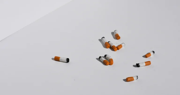 Cigarette butts scattered on a white surface