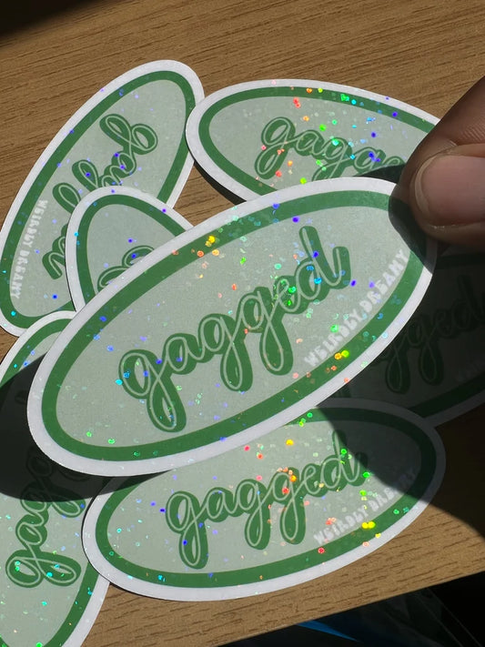 Green and white stickers with 'gagged' text on a wooden surface
