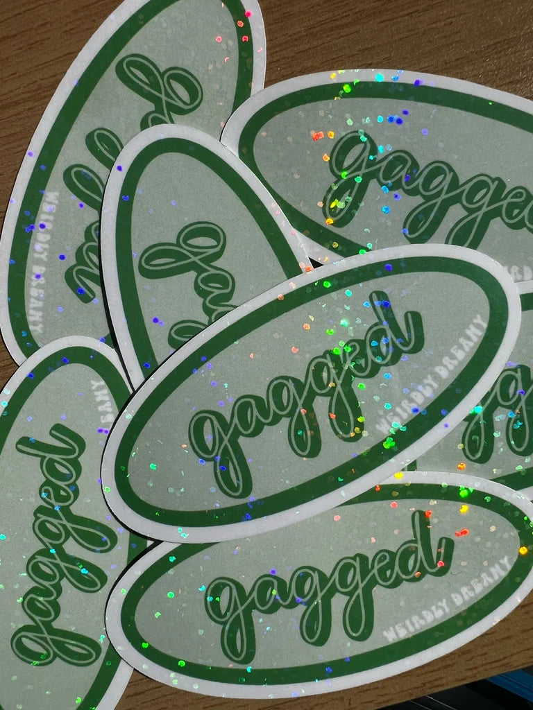 Multiple 'gagged' stickers with green text on a reflective surface