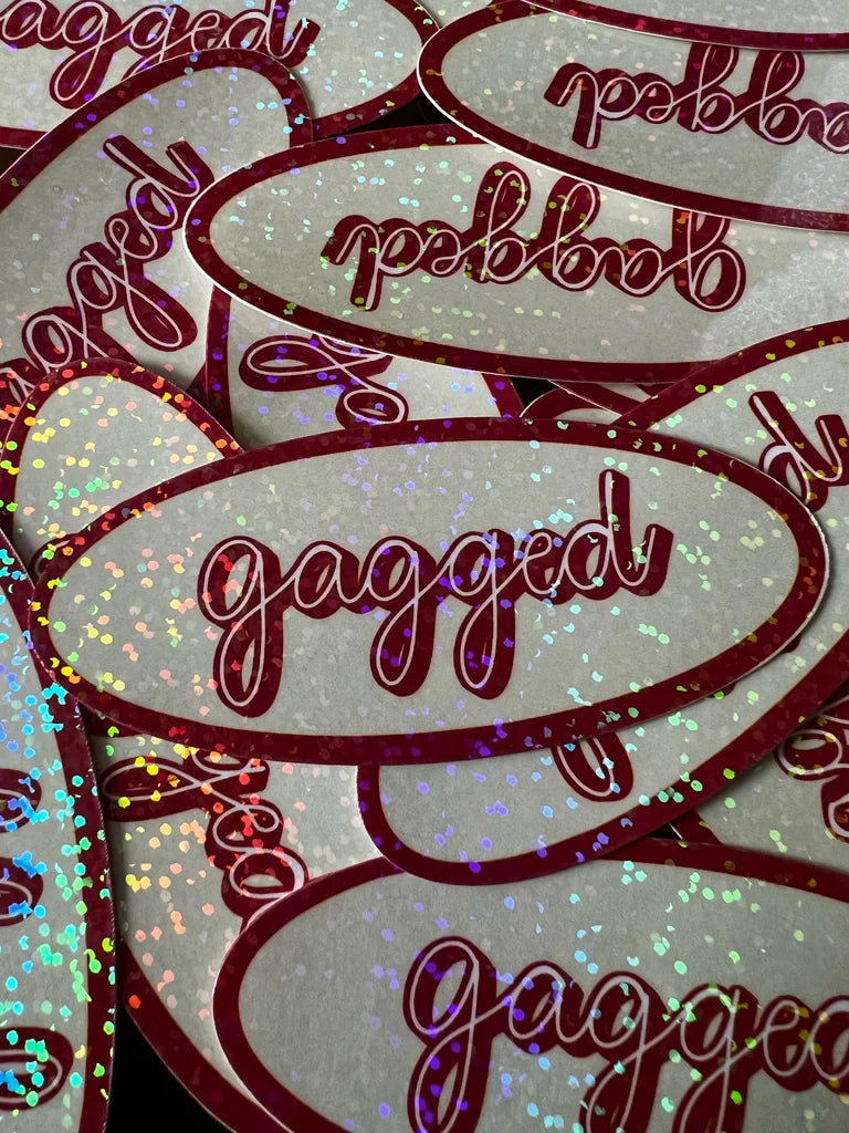 Multiple 'gagged' stickers with glittery text on a light background
