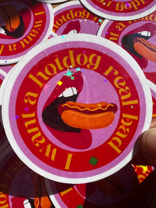 Circular sticker with cartoon hotdog and text 'I want a hotdog real bad' on a red background.