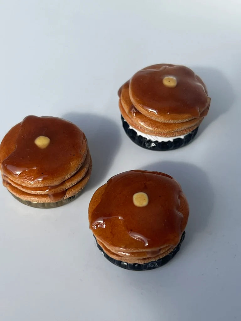 Three miniature pancakes stacked on a white background
