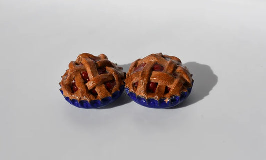 Pair of miniature cherry pie magnets on a white background. 