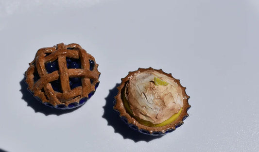 Two small decorative pie magnets on a white background