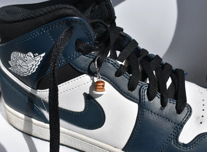 Close-up of a blue and white sneaker with black laces on a light gray background