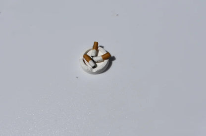Small decorative item resembling a cigarette on a light gray background