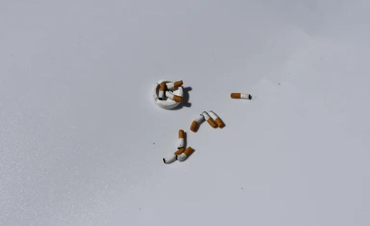 Cigarette butts arranged in the shape of a number '5' on a light gray background