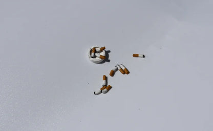 Cigarette butts arranged in the shape of a number '5' on a light gray background