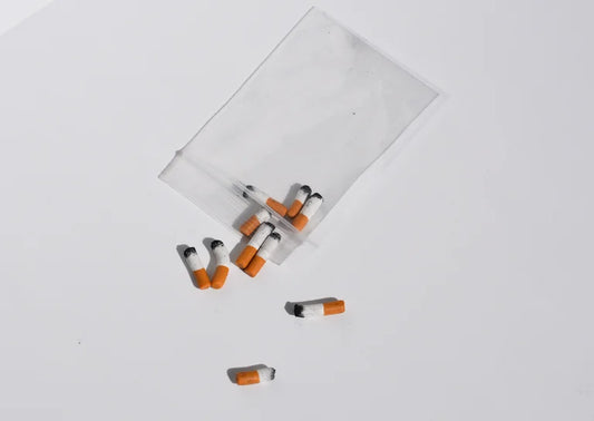 Miniature handmade cigarettes on a white background