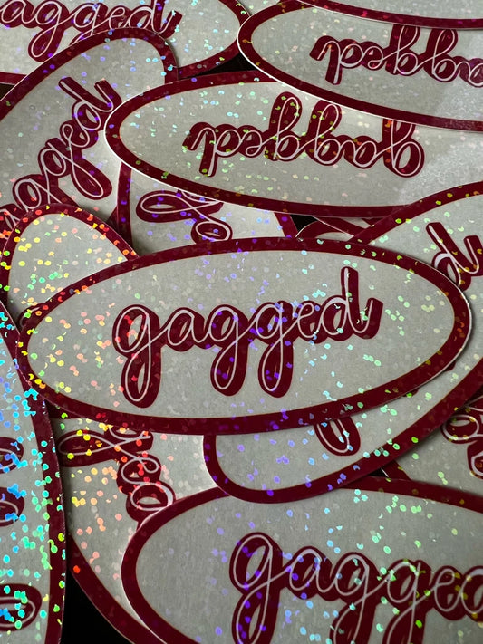 Multiple 'gagged' stickers with glittery text on a light background