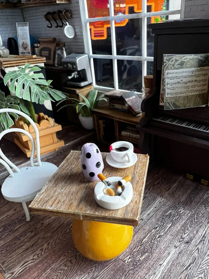 Small wooden table with a yellow base in a cozy room with plants and a piano.