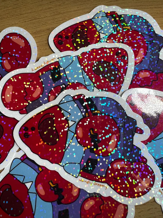 Glittery red and blue stickers with cartoonish design on a wooden surface