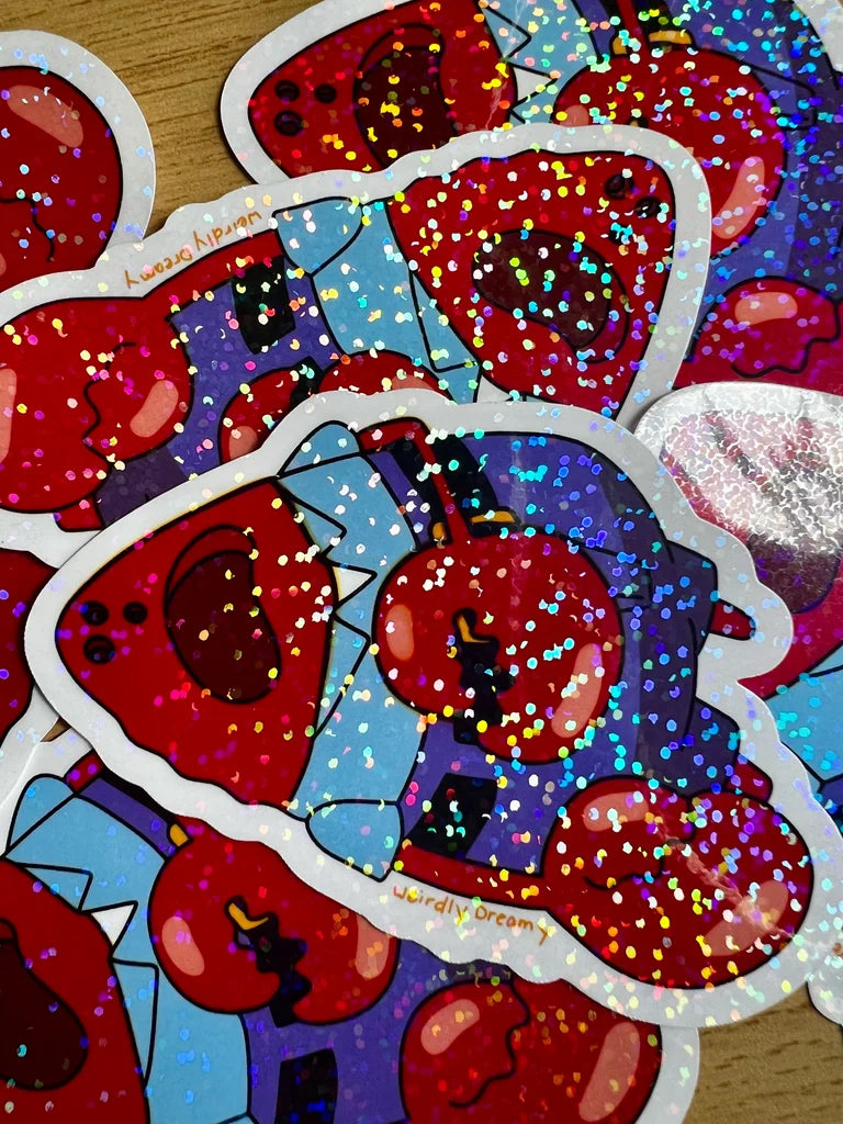 Glittery red and blue stickers with cartoonish design on a wooden surface